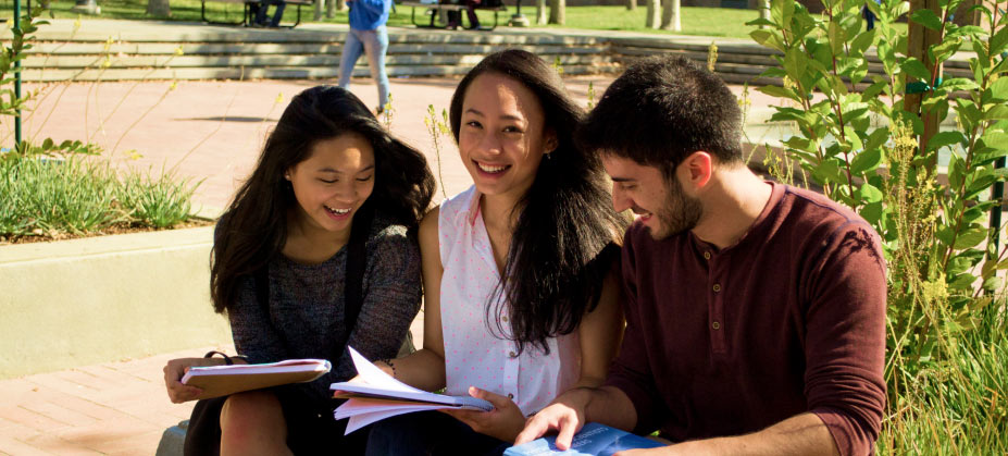 smiling students study outdoors