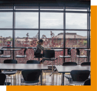 student at table by large windows